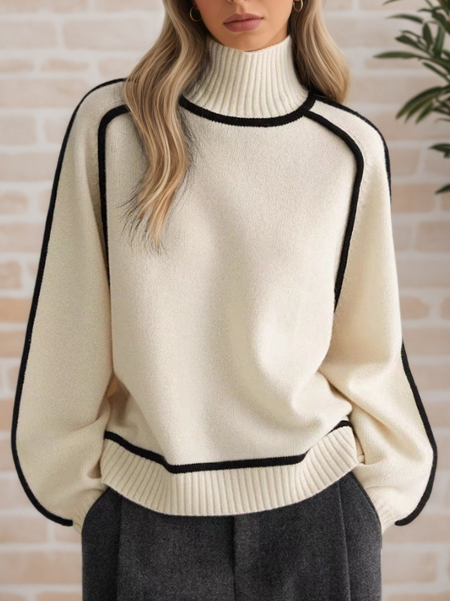 A woman wearing a funnel neck sweater with contrast piping, styled with pants for a smart-casual look.