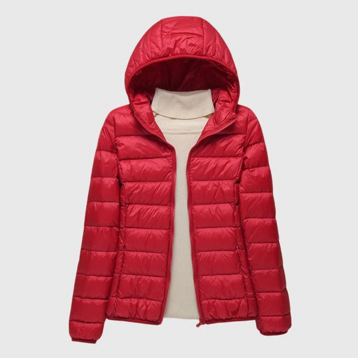 A woman wearing a lightweight padded jacket with a hood, outdoors on a cool day