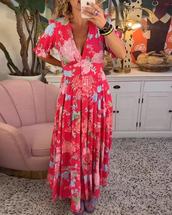 A woman wearing the Dawn bold floral maxi dress with a flowing full-length skirt at a garden gathering.