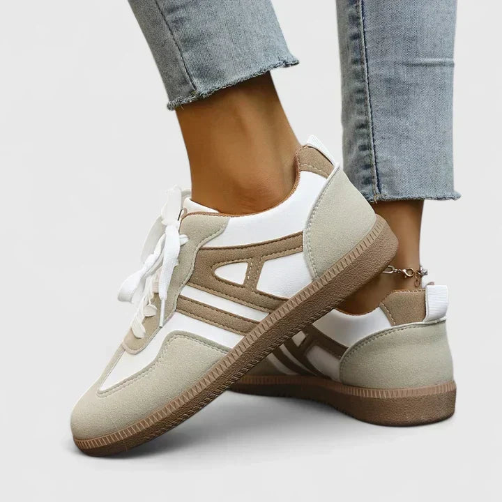 A woman wearing khaki and white orthopaedic sneakers on a relaxed walk.