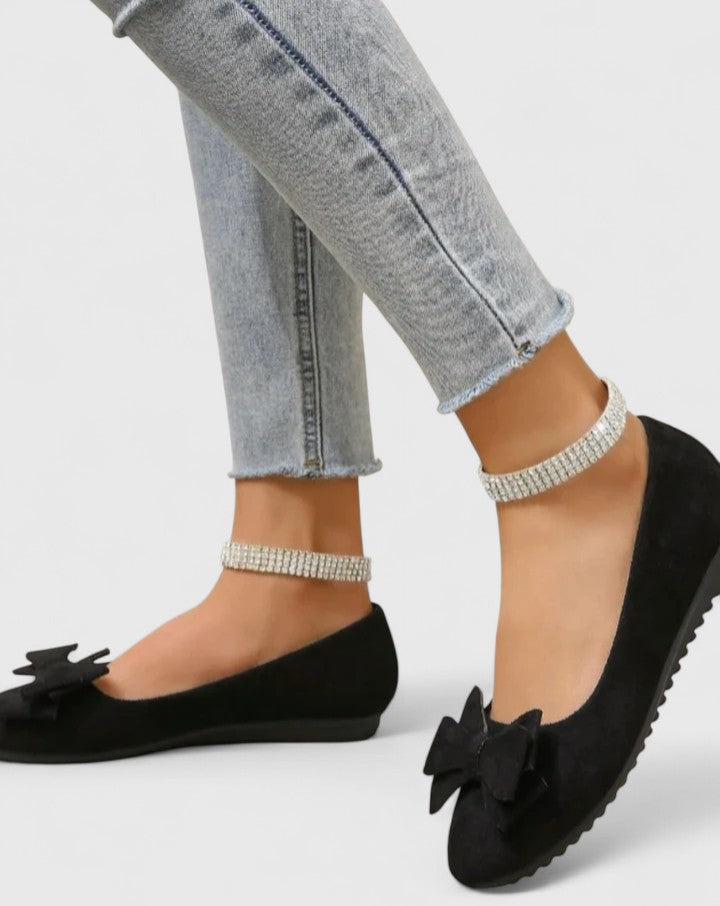 A pair of olive-green ballet flats with a soft bow at the rounded toe.