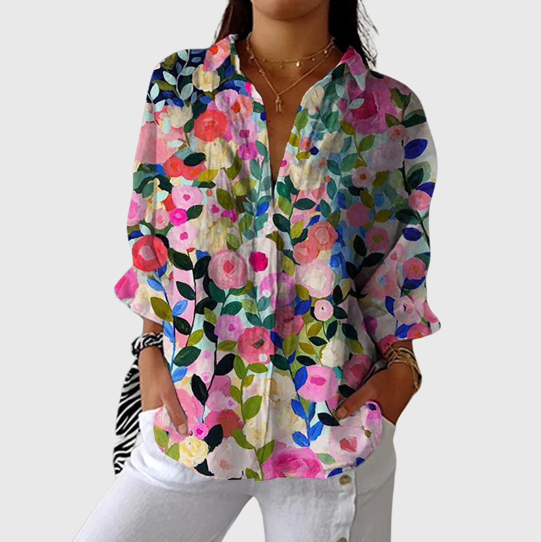 A woman wearing a loose colourful printed blouse with adjustable sleeves, styled with jeans for a bright, comfortable day out.