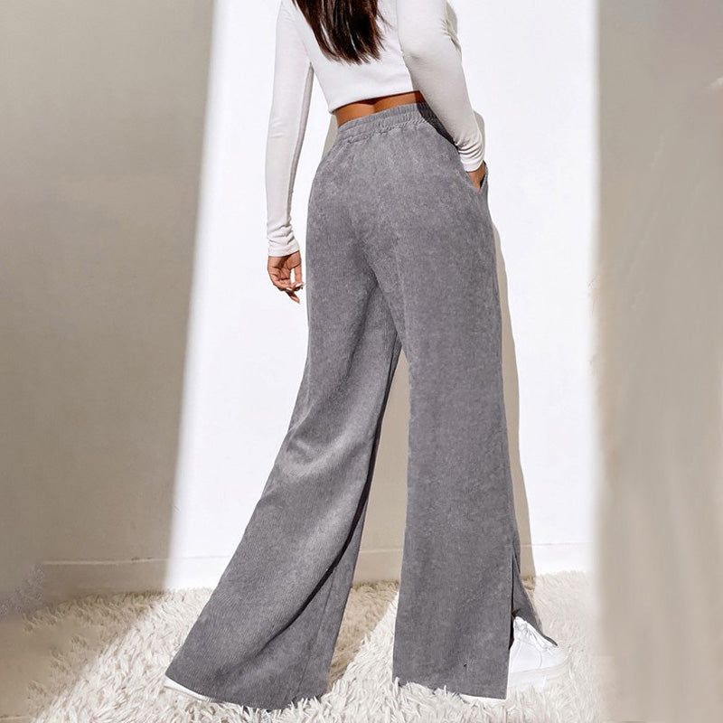 Woman wearing wide-leg ribbed joggers with a fitted top, relaxed at home.