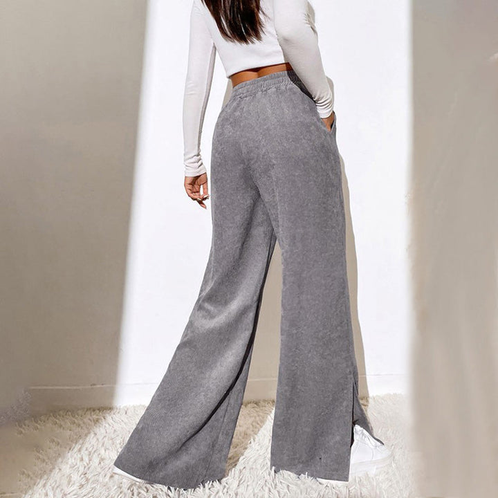 Woman wearing wide-leg ribbed joggers with a fitted top, relaxed at home.