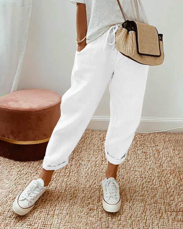 A woman wearing flowing elegant pants with a soft elastic waist and deep pockets.