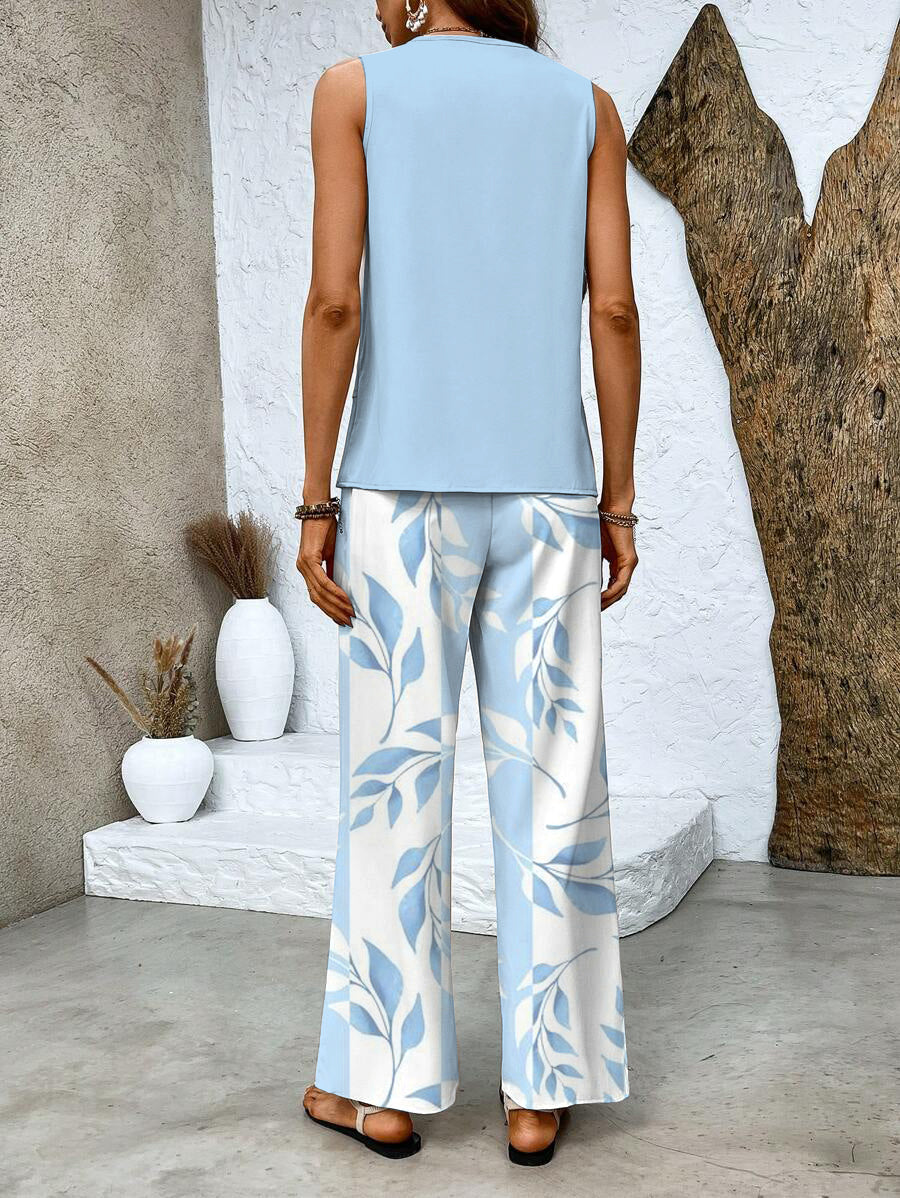 A woman wearing a layered sleeveless top with leaf-print wide-leg pants, light and elegant.