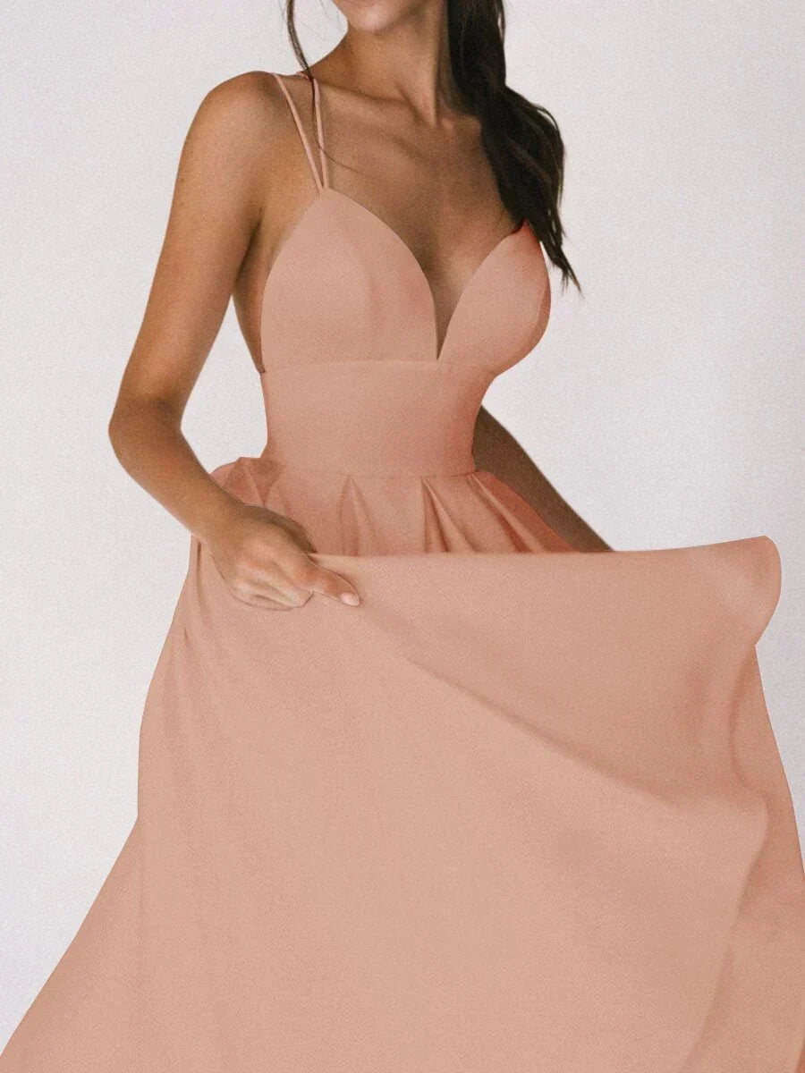 Woman at a summer celebration wearing the Beth minimalist maxi dress with fine double straps and a floating skirt.