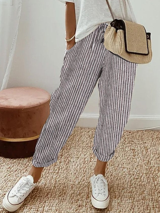 A woman wearing flowing elegant pants with a soft elastic waist and deep pockets.