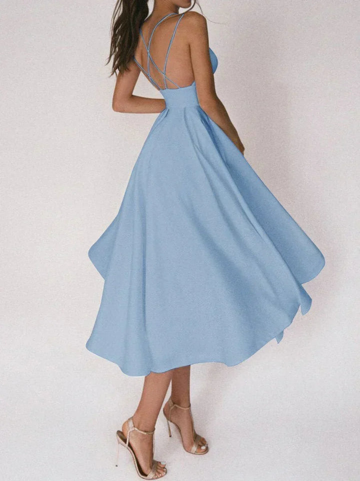 Woman at a summer celebration wearing the Beth minimalist maxi dress with fine double straps and a floating skirt.