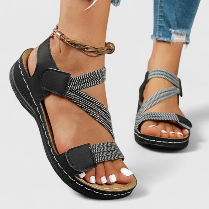 A woman wearing soft adjustable comfort sandals with a summer outfit, looking relaxed and content.