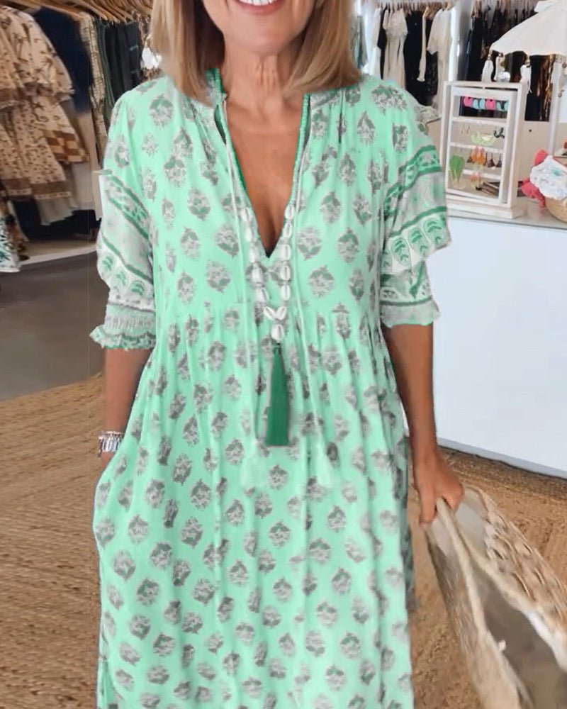 A woman wearing the Tracy boho floral midi dress with a fringed neckline and ruffled skirt.