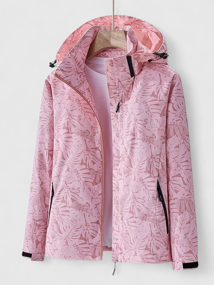 A woman wearing a botanical leaf-print jacket with a hood outdoors