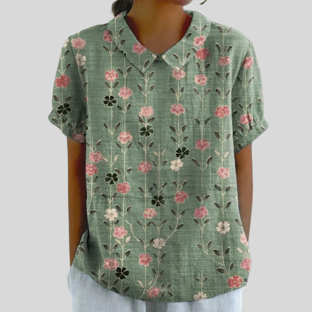 A woman wearing a flowing floral top with a refined collar on a relaxed morning outing.