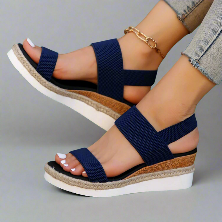 A woman wearing pink platform comfort sandals with a broad, cushioned footbed at an evening event.