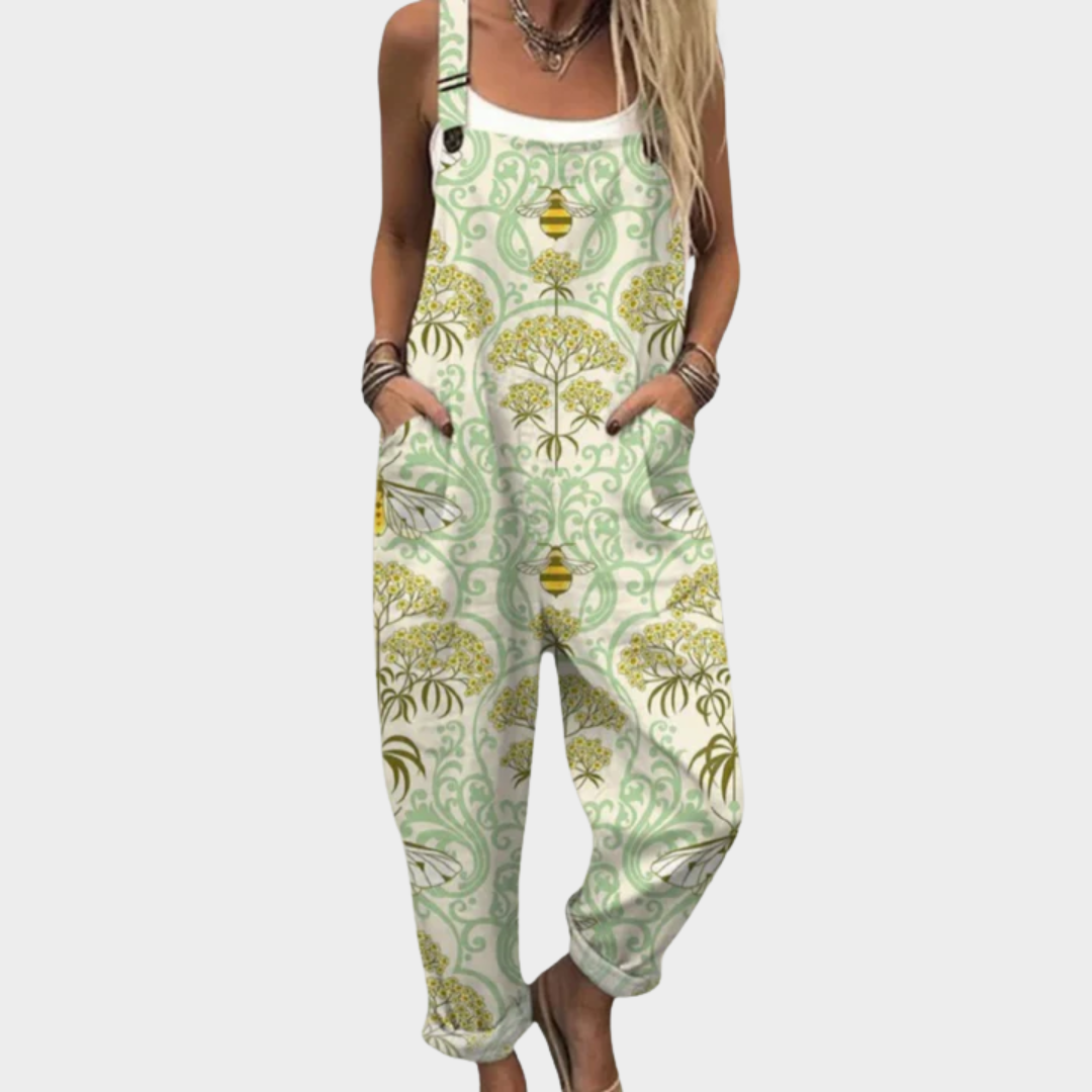 Woman wearing cream overalls printed with golden blossoms, soft sage scrolls and little bees