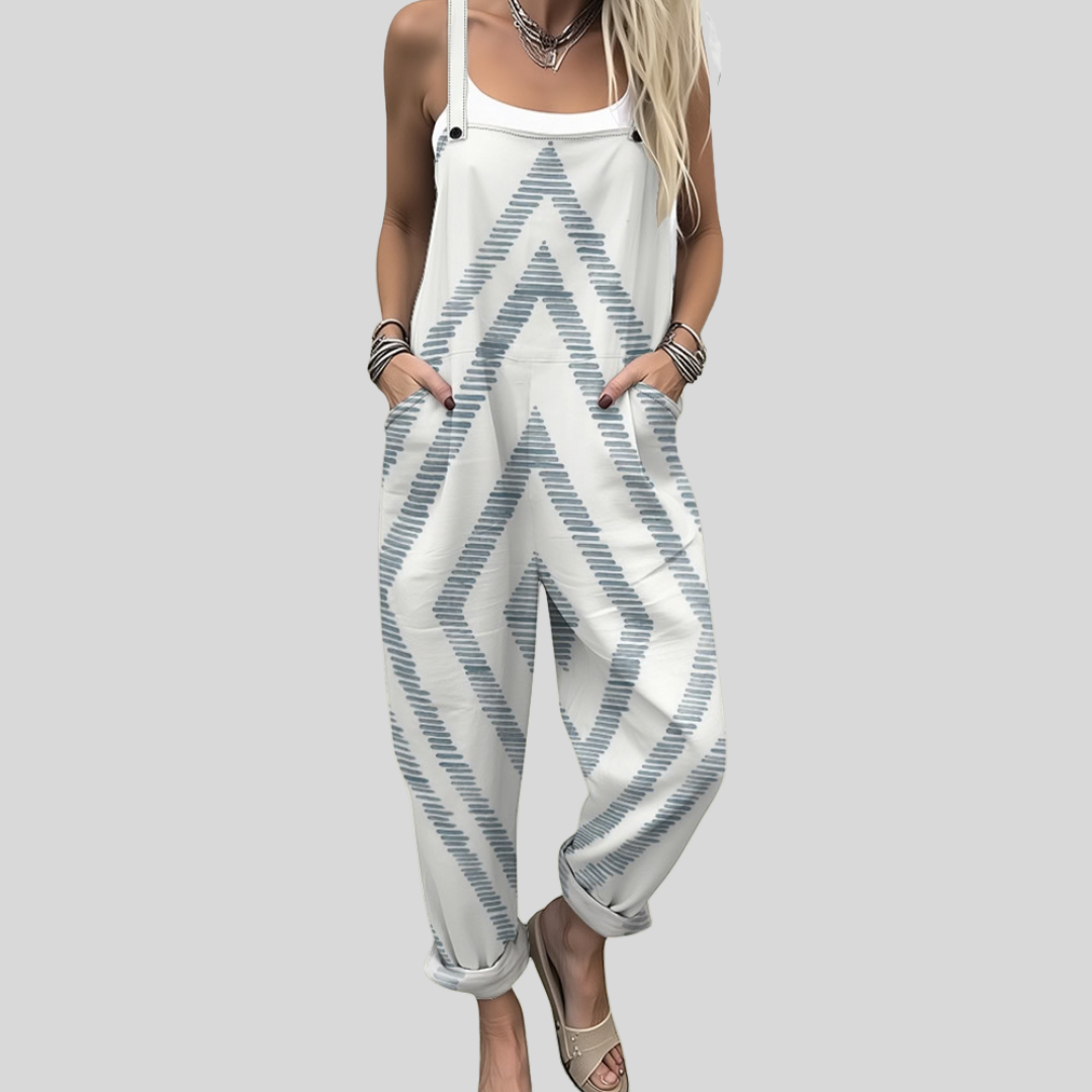 A woman wearing white overalls with a soft blue-grey zigzag pattern, relaxed and at ease in town.