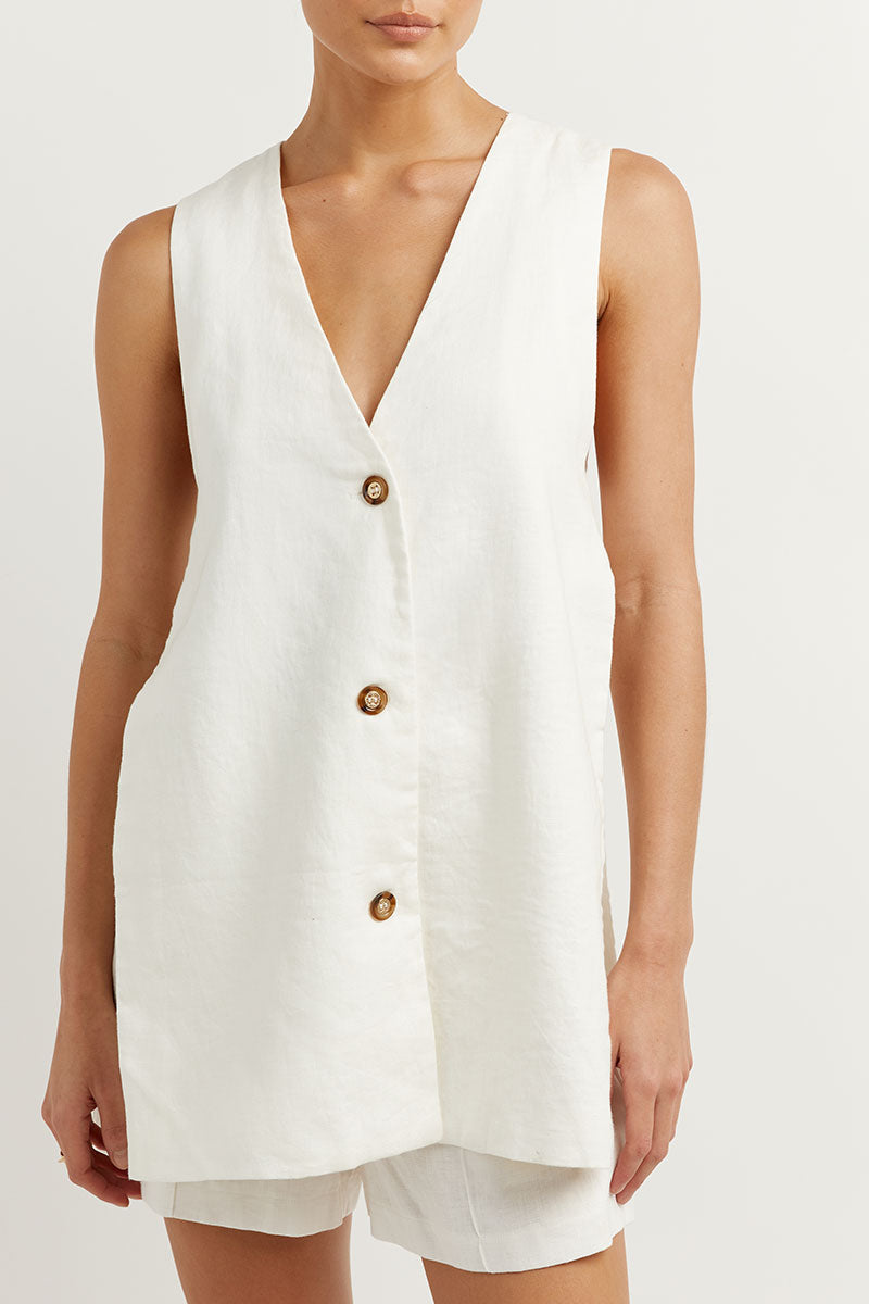 A woman wearing a sleeveless buttoned two-piece set