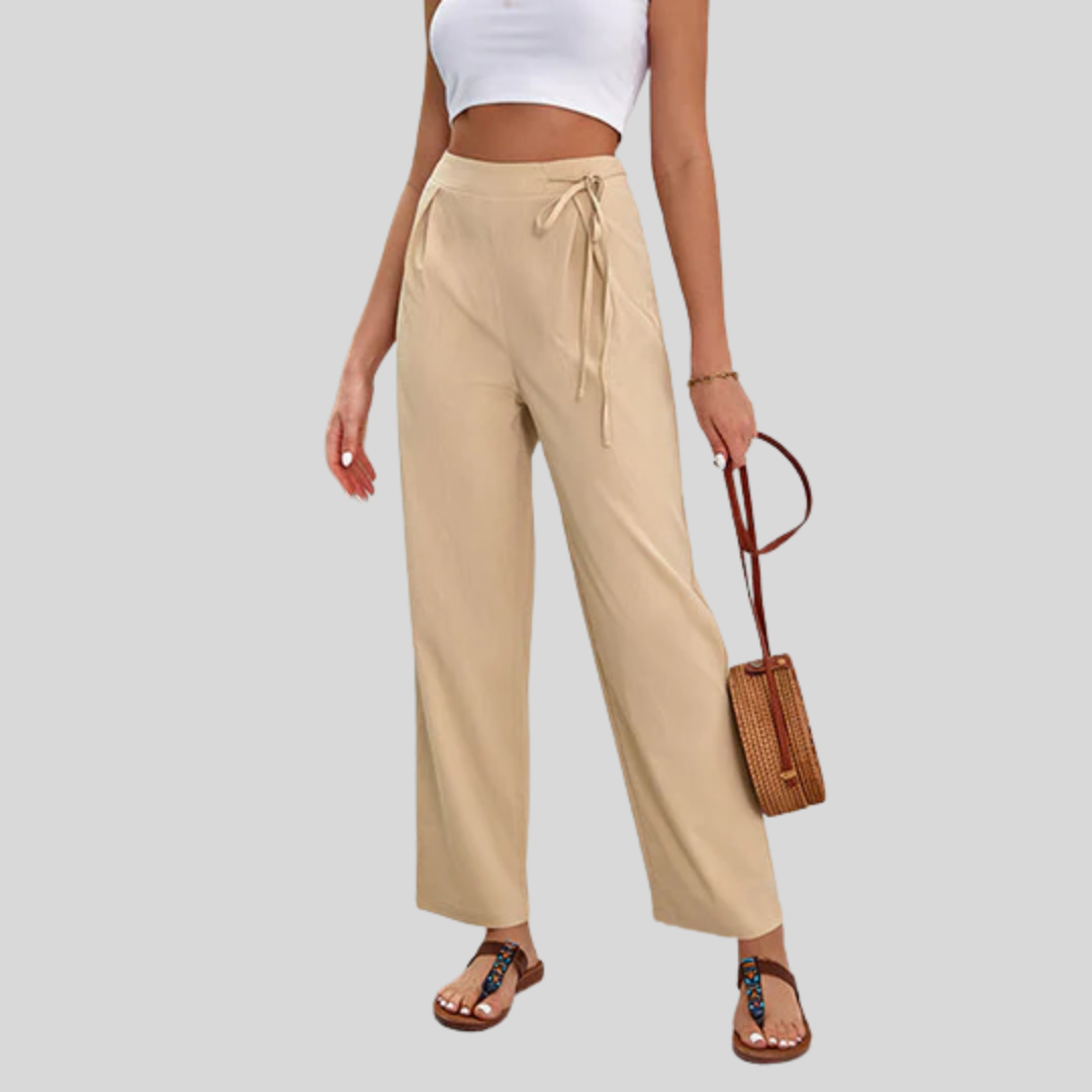 Woman wearing high-waisted wide-leg pants with a knot detail and a tucked-in top.