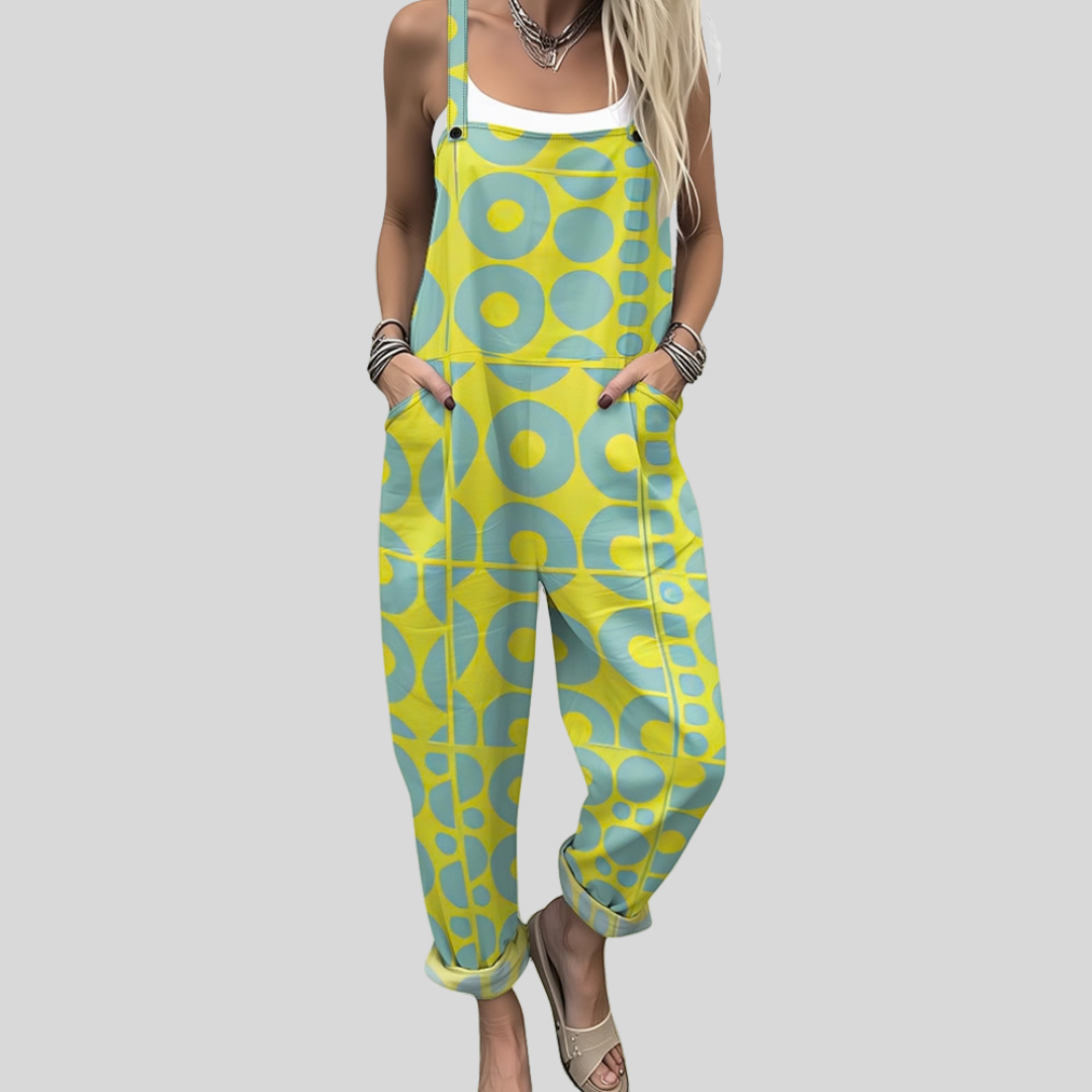 A woman wearing overalls with a bright yellow and turquoise retro geometric pattern, smiling on a sunny day.