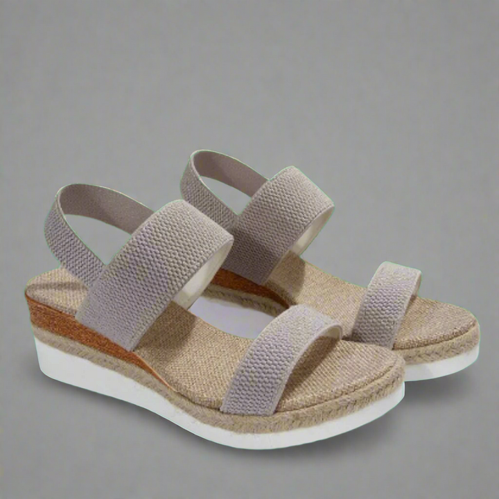 A woman wearing pink platform comfort sandals with a broad, cushioned footbed at an evening event.