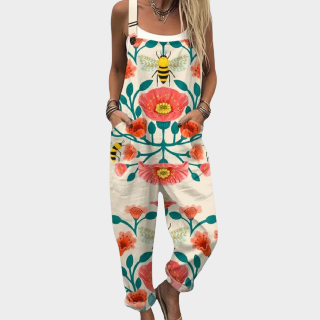 A woman wearing poppy-and-bee print overalls with a relaxed fit and adjustable straps.