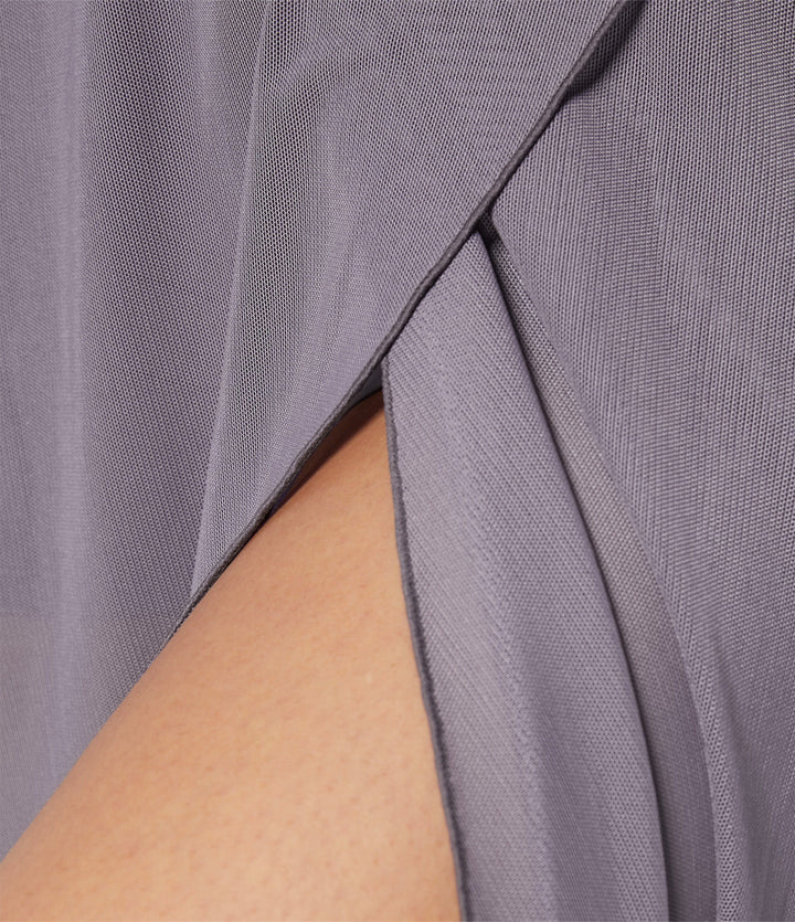 A woman in an elegant high-waisted flowing skirt, styled for a versatile day-to-evening look.