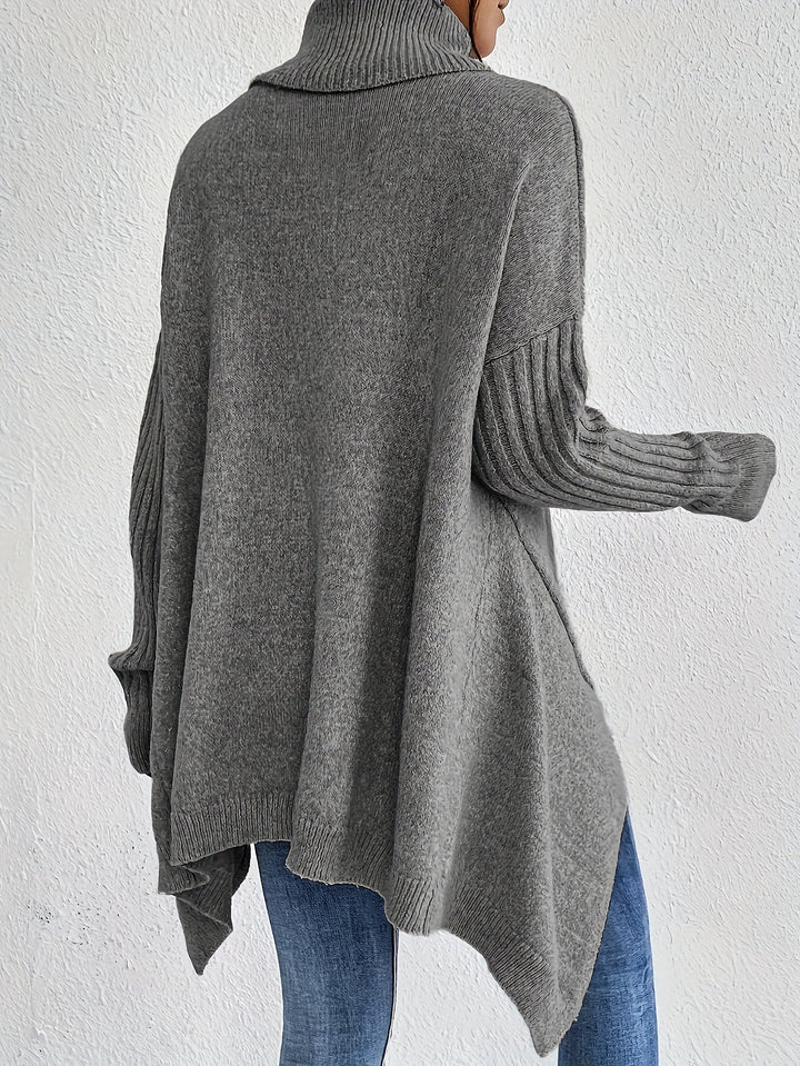 A woman wearing a stand-collar sweater with a chic asymmetric drape, warm and polished.