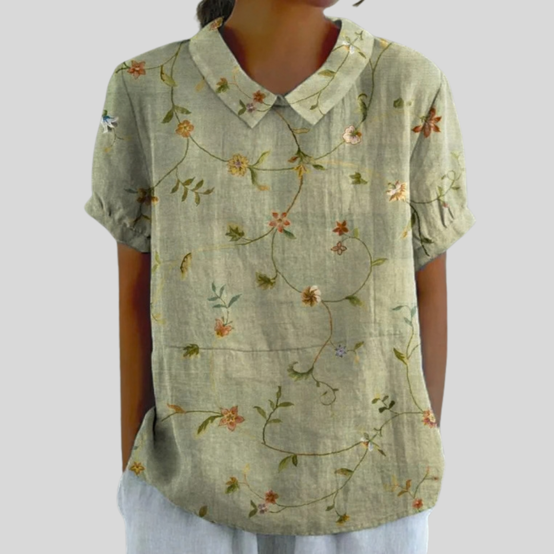 A woman wearing a floral top with a polo collar on a relaxed day out