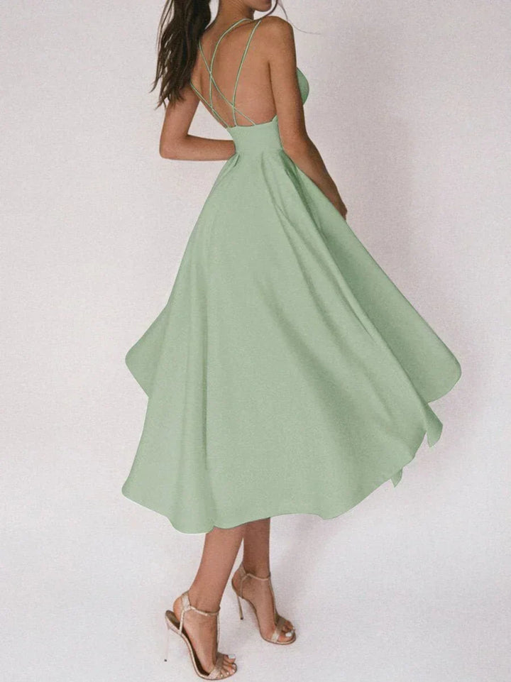 Woman at a summer celebration wearing the Beth minimalist maxi dress with fine double straps and a floating skirt.