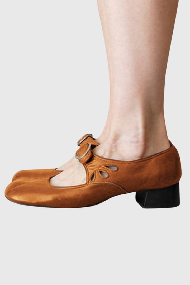 A woman wearing low heel Mary Janes with an adjustable strap, dressed for work.