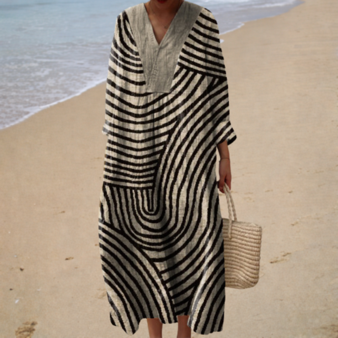 A woman wearing a loose, flowing printed summer dress that drapes softly as she walks in the sunshine.