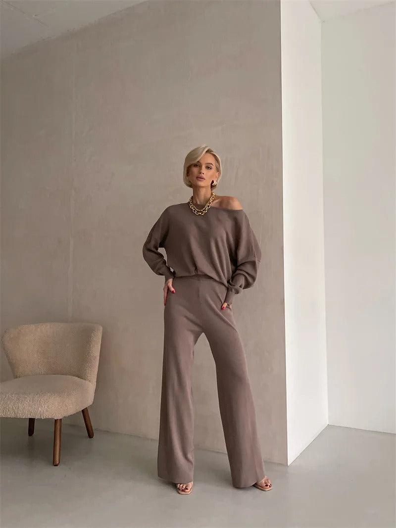 A woman wearing an off-shoulder draped top with wide-leg pants