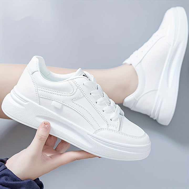 A woman in crisp white light comfort sneakers paired with jeans.