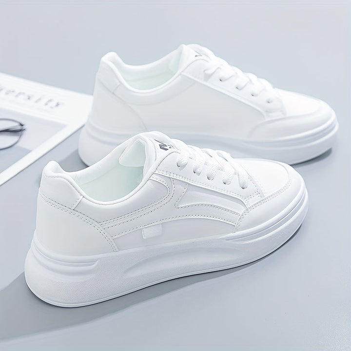 A woman in crisp white light comfort sneakers paired with jeans.