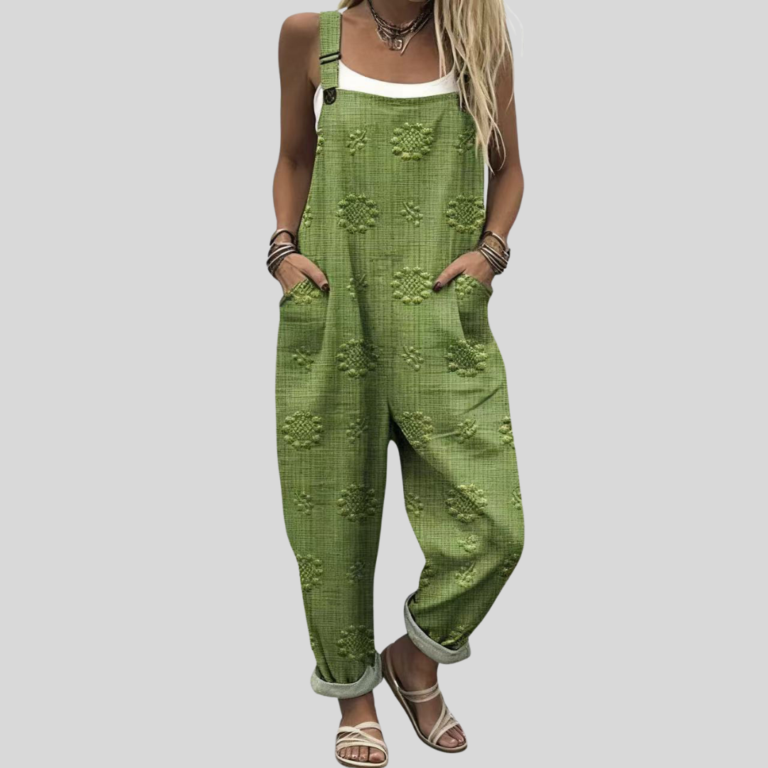 A woman wearing warm olive green overalls with a relaxed fit and adjustable straps, styled with a white tee.