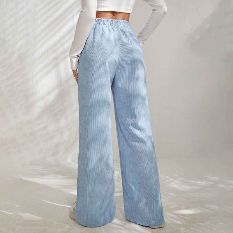 Woman wearing wide-leg ribbed joggers with a fitted top, relaxed at home.