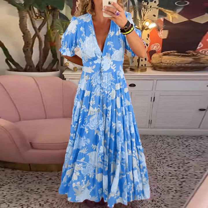 A woman wearing the Dawn bold floral maxi dress with a flowing full-length skirt at a garden gathering.