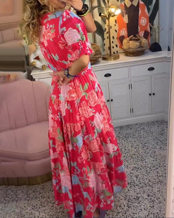 A woman wearing the Dawn bold floral maxi dress with a flowing full-length skirt at a garden gathering.