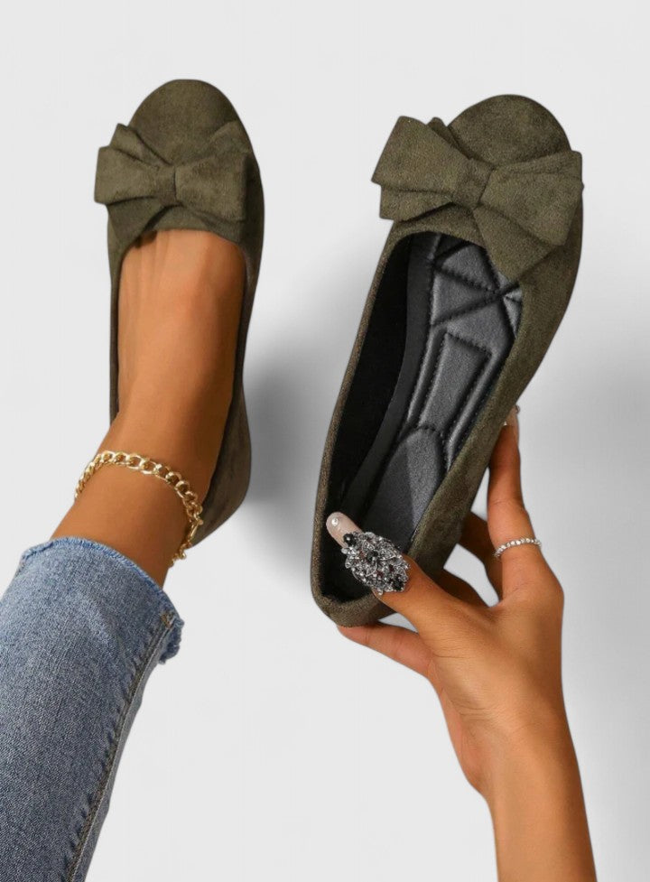 A pair of olive-green ballet flats with a soft bow at the rounded toe.