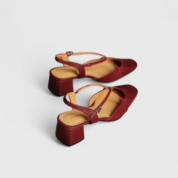 Burgundy closed square-toe flats with criss-cross instep straps and a buckled slingback.