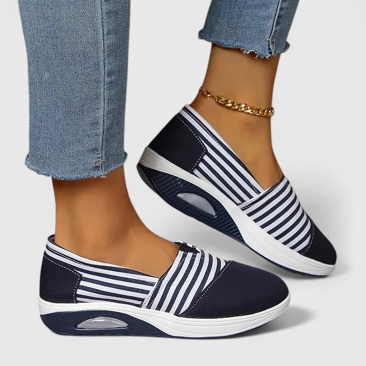 A woman wearing blue striped orthopaedic sneakers on a walk