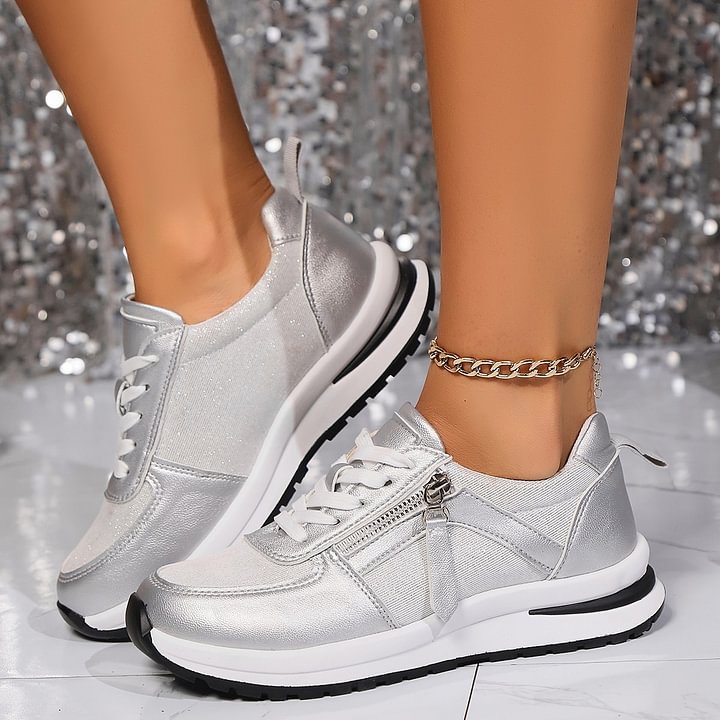 A woman in silver orthopaedic sneakers with a handy side zip.