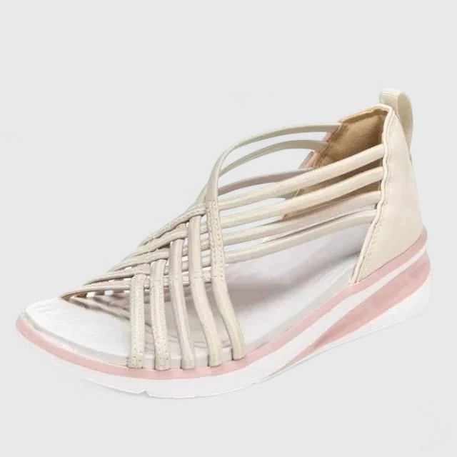 A woman walking comfortably in wide-fit multi-strap orthopaedic sandals with an open design.
