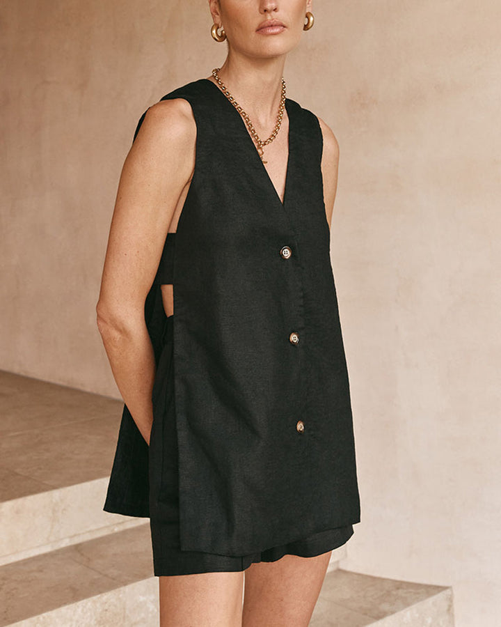 A woman wearing a sleeveless buttoned two-piece set