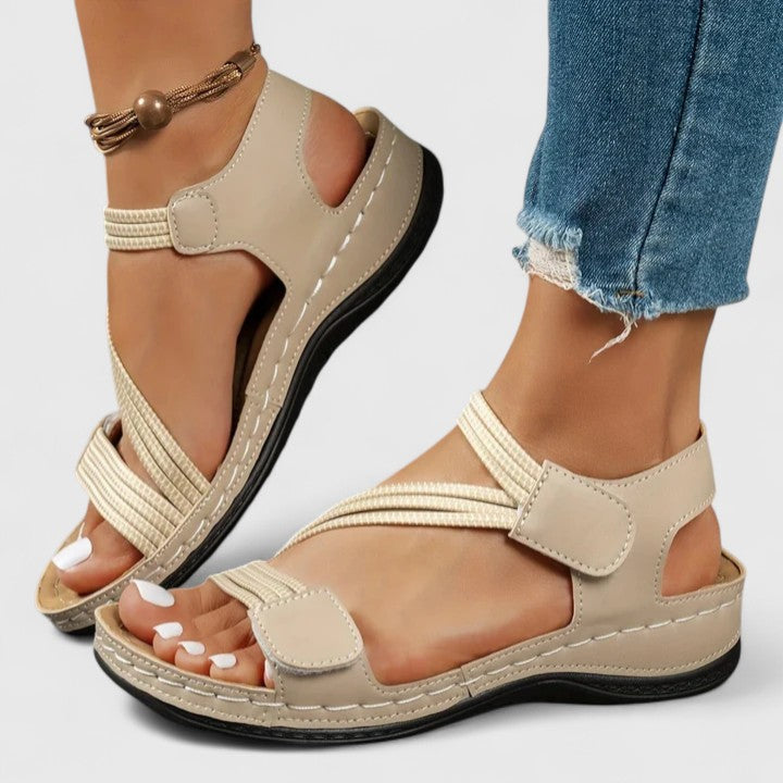 A woman wearing soft adjustable comfort sandals with a summer outfit, looking relaxed and content.