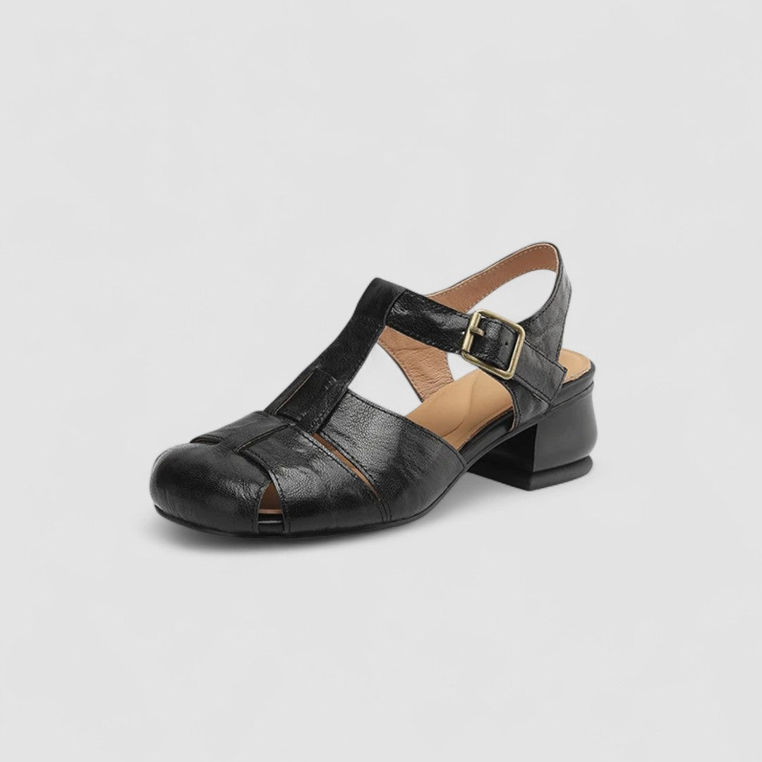 A woman in burgundy closed-toe woven sandals with a low block heel, comfortable browsing a market.