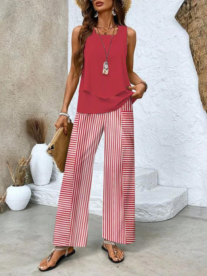 A woman wearing a layered sleeveless top with leaf-print wide-leg pants, light and elegant.