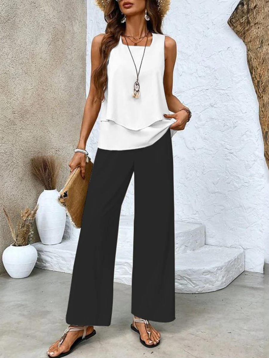 A woman wearing a layered sleeveless top with leaf-print wide-leg pants, light and elegant.