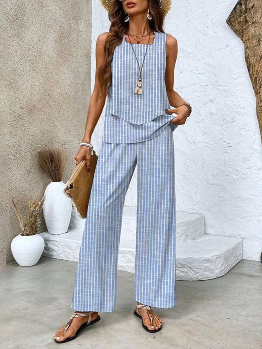 A woman wearing a layered sleeveless top with leaf-print wide-leg pants, light and elegant.