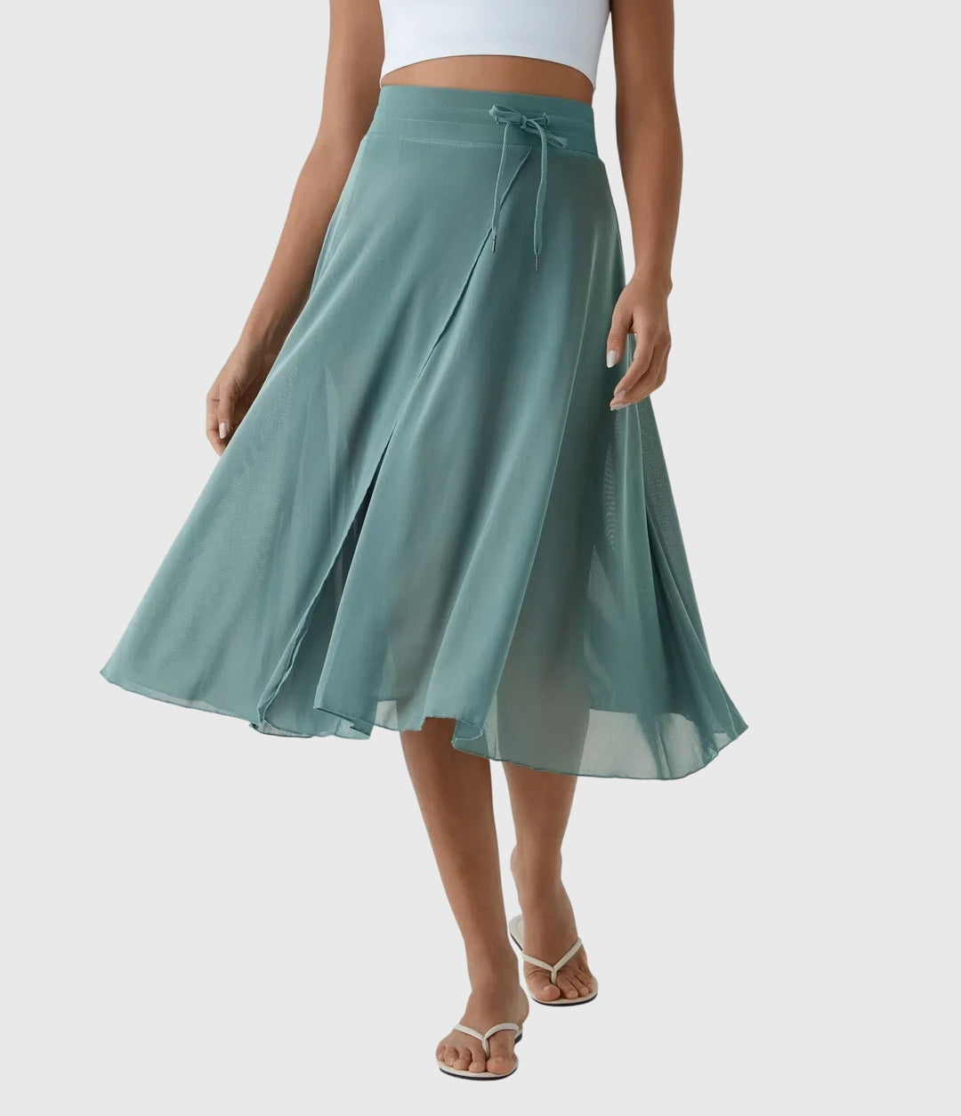 A woman in an elegant high-waisted flowing skirt, styled for a versatile day-to-evening look.